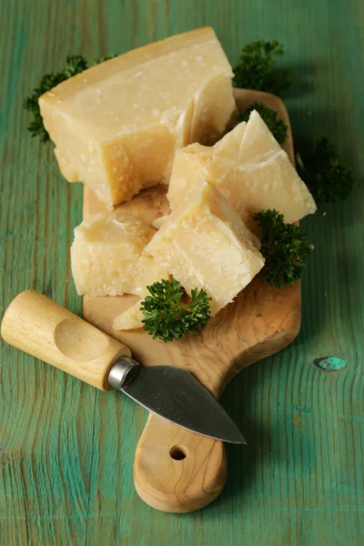 Morceau de parmesan naturel sur une planche de bois — Photo