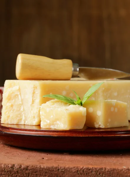 Stuk van natuurlijke Parmezaanse kaas op een houten bord — Stockfoto