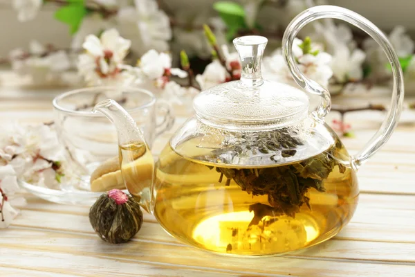 Glass teapot with exotic green tea on a wooden table — Stock Photo, Image