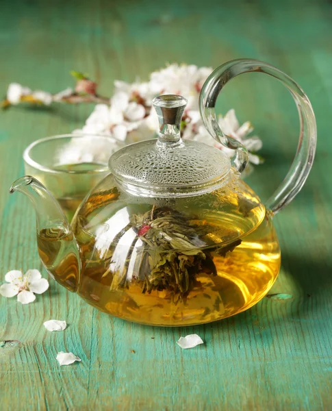 Glass teapot with exotic green tea on a wooden table — Stock Photo, Image