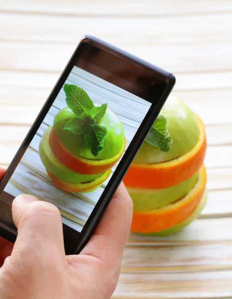 Smartphone scatto foto cibo - fette mela verde e arancia — Foto Stock