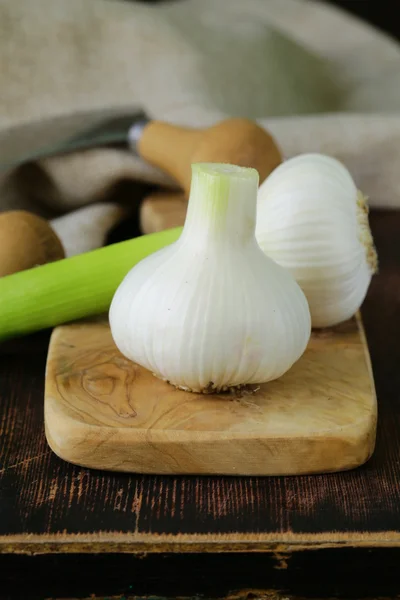 Ajo orgánico fresco en un tablero de cocina de madera — Foto de Stock