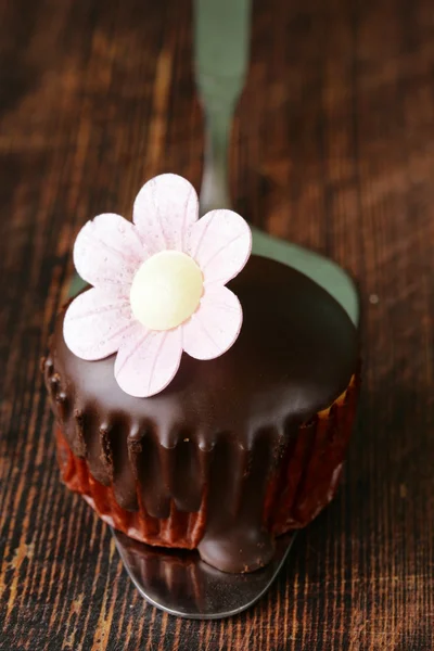 Sweet cupcake met chocolade kers op een houten achtergrond — Stockfoto