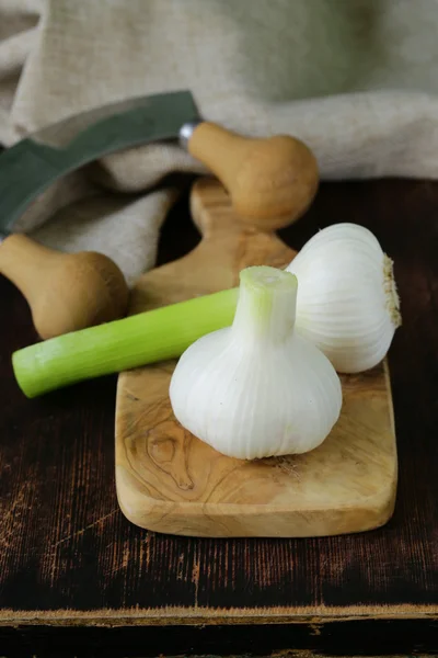 Aglio fresco biologico su una tavola da cucina in legno — Foto Stock