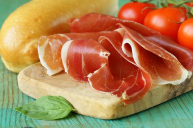 Parma jambonu (jamon) ahşap bir tahta üzerine dilimlenmiş
