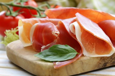 Parma jambonu (jamon) ahşap bir tahta üzerine dilimlenmiş