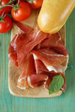 Parma jambonu (jamon) ahşap bir tahta üzerine dilimlenmiş