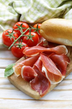 Parma jambonu (jamon) ahşap bir tahta üzerine dilimlenmiş