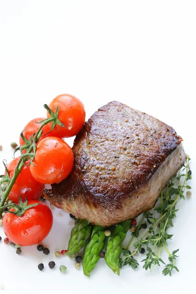 Mięso z grilla steki wołowe z garnish warzyw (szparagi i pomidory) — Zdjęcie stockowe