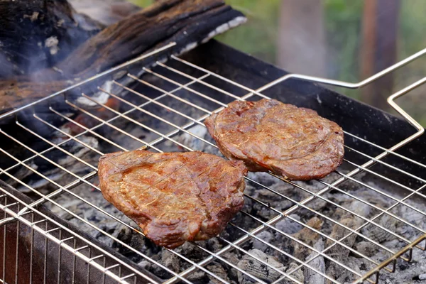 Beef steak grilled on a barbecue outdoors — Stock Photo, Image