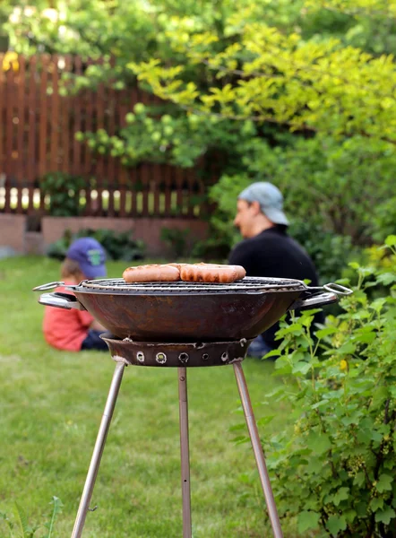 Saucisses rôties sur une grille barbecue en plein air pique-nique — Photo