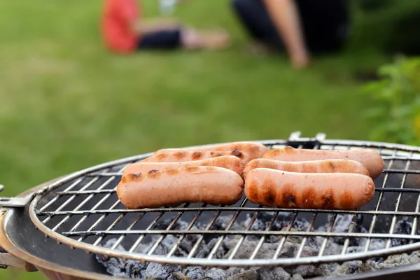 Saucisses rôties sur une grille barbecue en plein air pique-nique — Photo