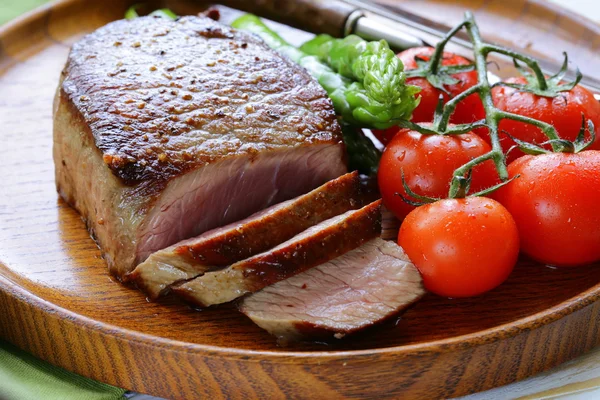 Bife de carne grelhada com guarnição de vegetais (espargos e tomates ) — Fotografia de Stock