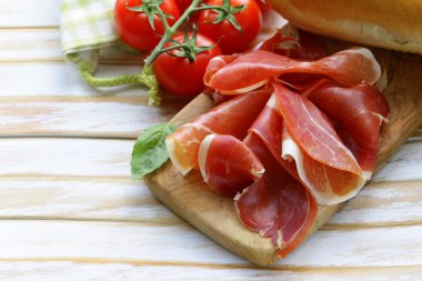 Parma jambonu (jamon) ahşap bir tahta üzerine dilimlenmiş