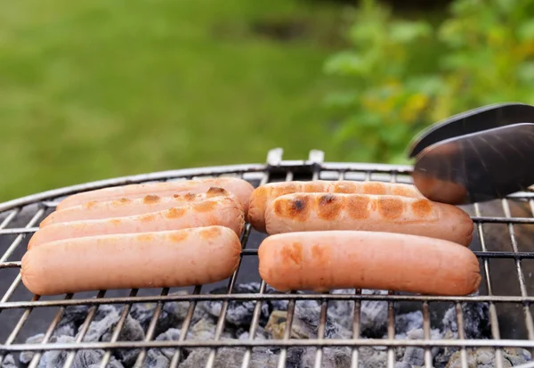 Saucisses rôties sur une grille barbecue en plein air pique-nique — Photo