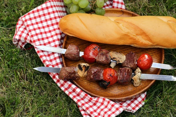 Carne assada nos espetos de fogo (shashlik) com tomates e cogumelos — Fotografia de Stock