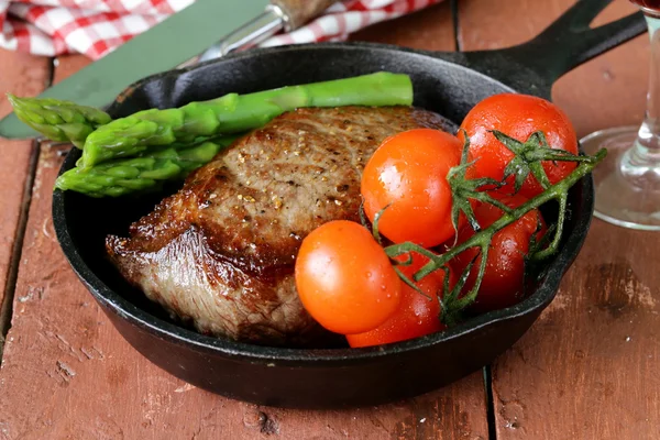 Bife de carne grelhada com guarnição de vegetais (espargos e tomates ) — Fotografia de Stock