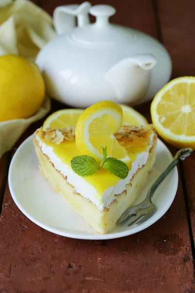Piece of lemon cake tart decorated with fresh lemon and mint