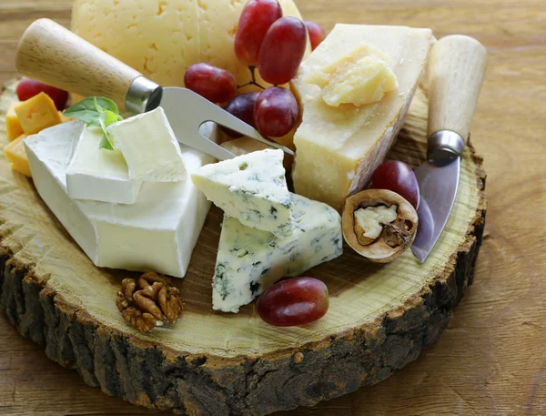 Cheeseboard with assorted cheeses (parmesan, brie, blue, cheddar) — Stock Photo, Image