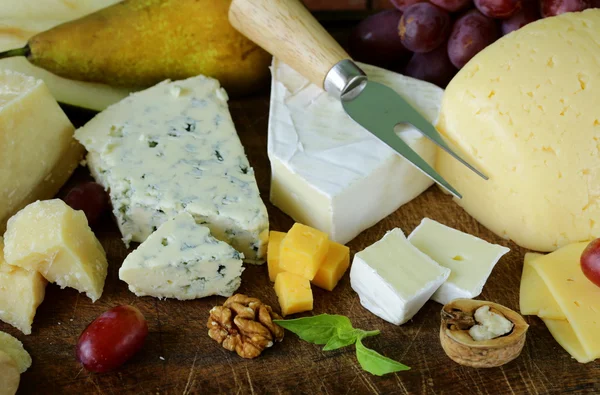 Cheeseboard with assorted cheeses (parmesan, brie, blue, cheddar) — Stock Photo, Image