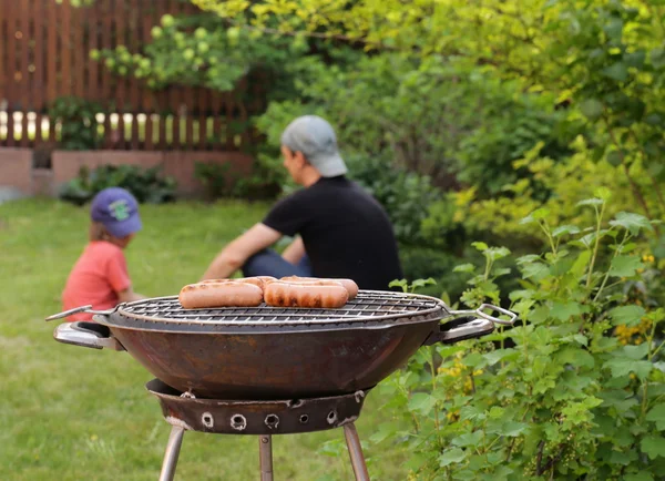 Saucisses rôties sur une grille barbecue en plein air pique-nique — Photo