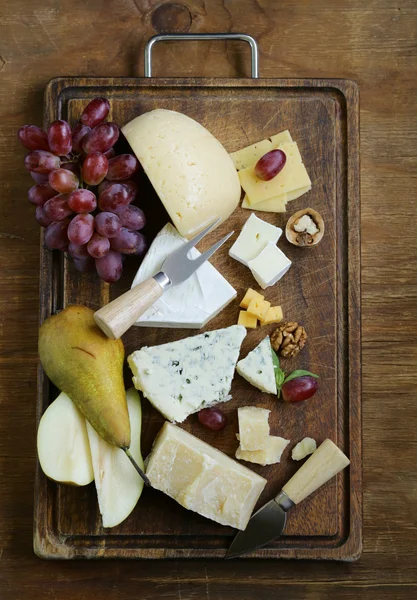 Сырная доска с разнообразными сырами (пармезан, бри, синий, чеддер ) — стоковое фото