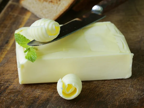 Fresh yellow butter served on a wooden board — Stock Photo, Image