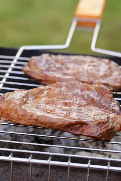 Steak de boeuf grillé sur un barbecue en plein air — Photo