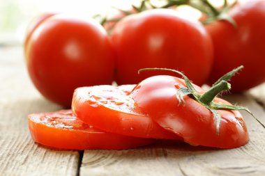 ahşap bir masa üzerinde taze olgun organik dilimlenmiş domates