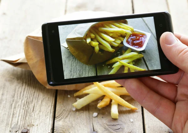 Снимок со смартфона - картошка фри с солью и кетчупом — стоковое фото