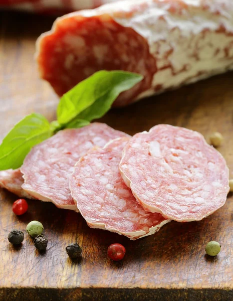 Salchicha ahumada delicadeza (salami) en una tabla de madera — Foto de Stock