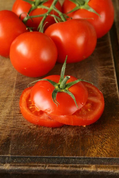 Pomodori freschi a fette biologici maturi su un tavolo di legno — Foto Stock