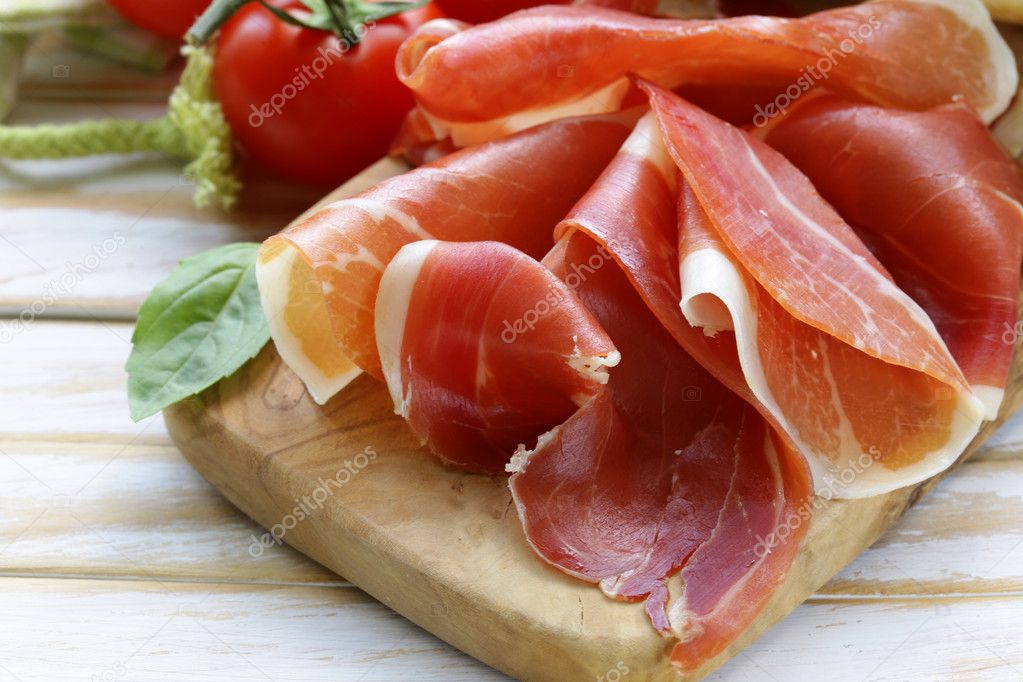Parma ham (jamon) sliced on a wooden board