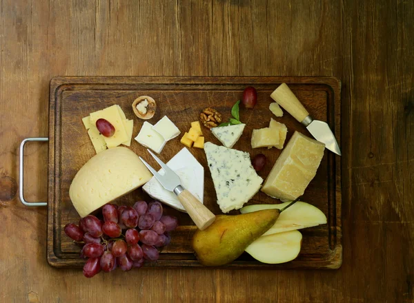 Сырная доска с разнообразными сырами (пармезан, бри, синий, чеддер ) — стоковое фото