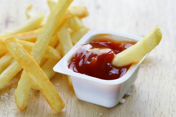 Traditionele aardappelen Franse frietjes met zout op houten achtergrond — Stockfoto