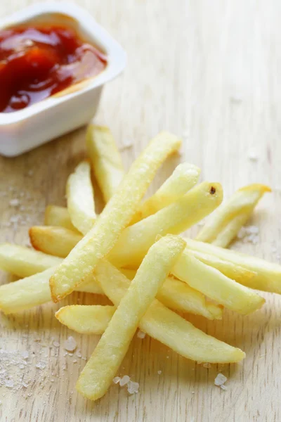 Traditionele aardappelen Franse frietjes met zout op houten achtergrond — Stockfoto