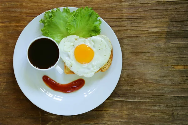 Grappig gezicht serveert ontbijt, gebakken ei, toast en groene salade — Stockfoto