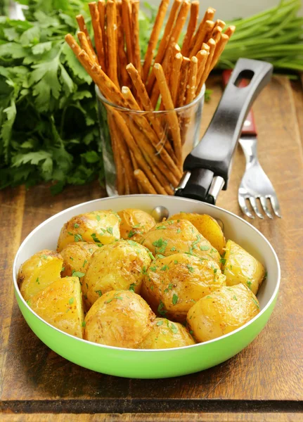 Tasty baked potatoes with herbs in the pan — Stock Photo, Image
