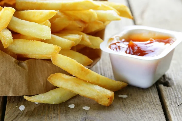 Traditionele aardappelen Franse frietjes met zout op houten achtergrond — Stockfoto