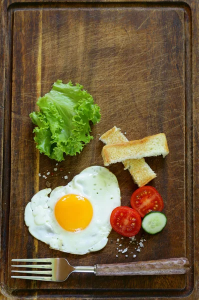 Fried egg with fresh vegetables and toast for breakfast — Stock Photo, Image
