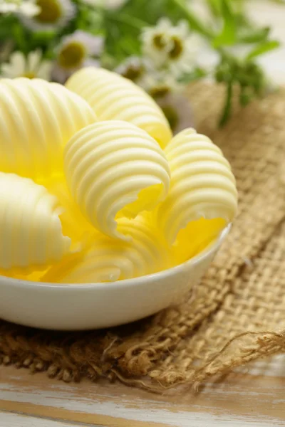 Mantequilla lechera amarilla fresca en un tazón blanco — Foto de Stock
