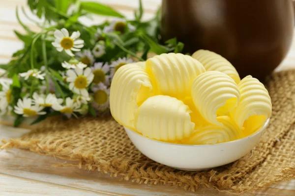 Mantequilla lechera amarilla fresca en un tazón blanco — Foto de Stock