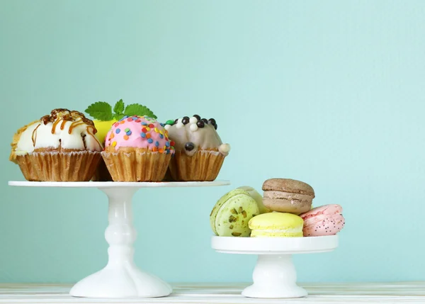 Святкові десерти, прикрашені кекси та барвисті макаруни — стокове фото