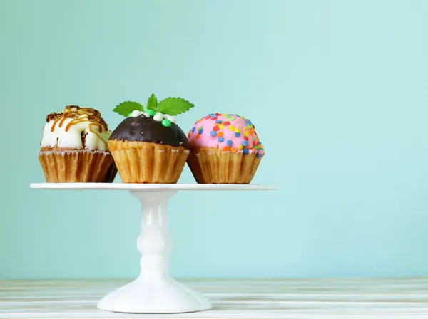 Праздничные десерты, различные украшенные кексы на стенде — стоковое фото