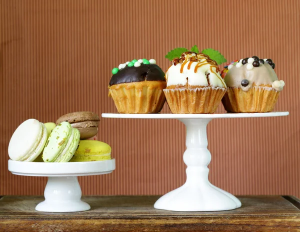 Sobremesas de férias, cupcakes decorados e macaroons coloridos — Fotografia de Stock