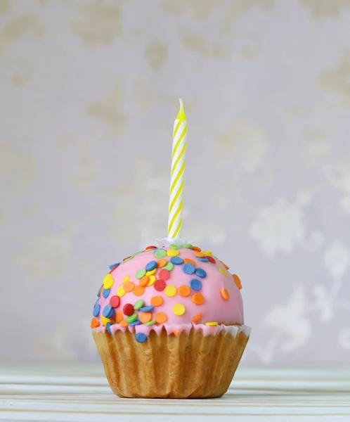 Birthday cupcake with a candle on a vintage background — Stock Photo, Image