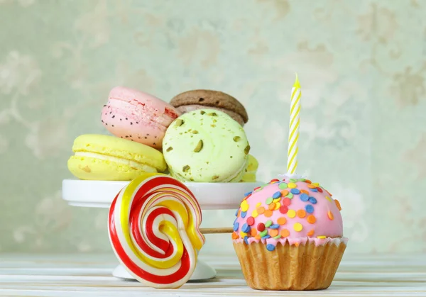 Birthday cupcake with a candle and holiday desserts — Stock Photo, Image