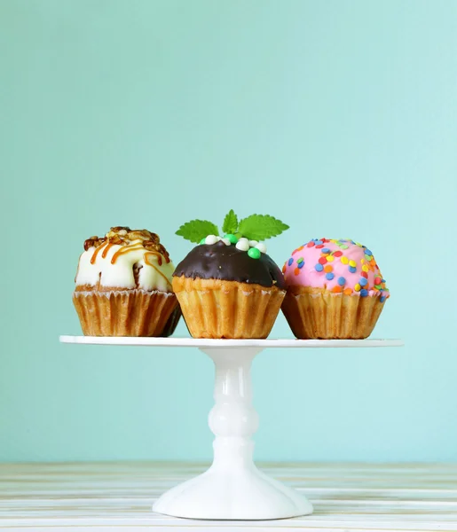 Святкові десерти, різні прикрашені кекси на підставці — стокове фото