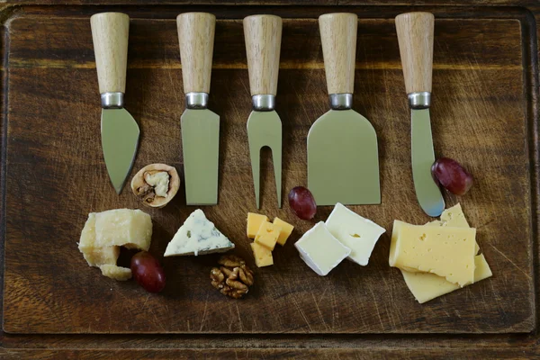 Tabla de quesos con una variedad de quesos (parmesano, brie, azul, cheddar ) — Foto de Stock
