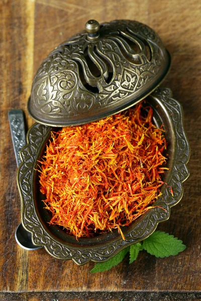 Saffron spice in metal bowl macro shot soft focus — Stock Photo, Image